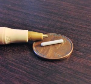 A close-up of a beige pen with a gold tip