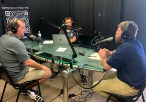 Three individuals participate in a podcast recording