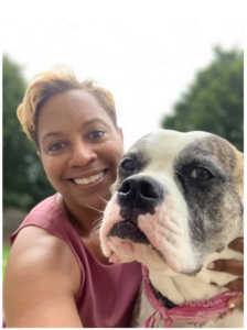 A close-up of Nelva holding a large, affectionate dog