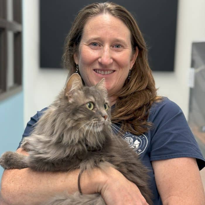 Dr. Nunnery holding a grey tabby cat.